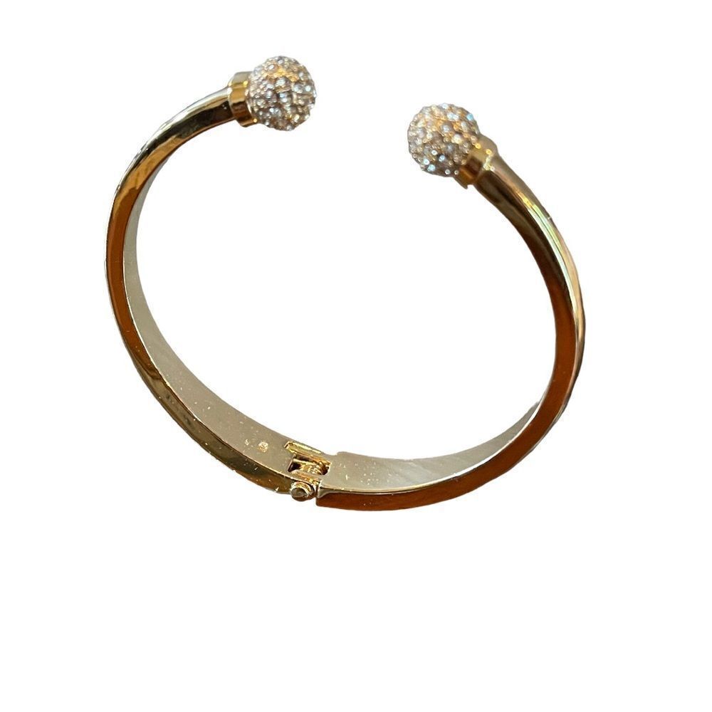 Gold tone bangle bracelet with two round crystal ends